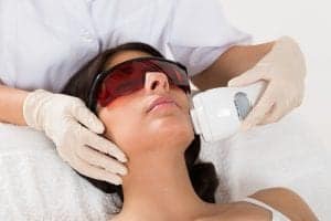 Close-up Of Beautician Giving Epilation Laser Treatment On Woman's Face